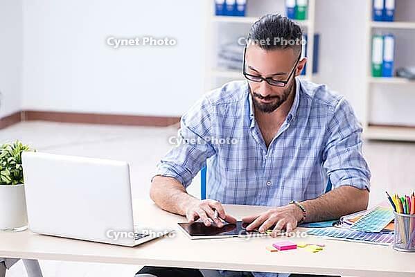 Young designer working in his studio on new project [IBR125094433]