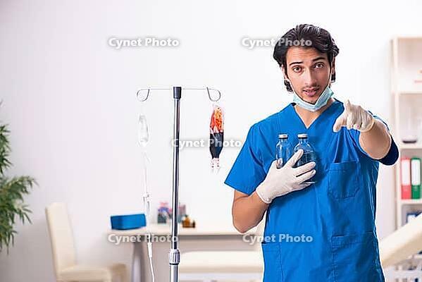 Young male doctor in blood transfusion concept [IBR125118000]