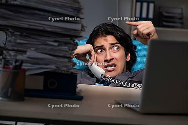 Young male employee working late at office [IBR125118017]