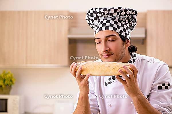 Young male baker working in kitchen [IBR125118025]