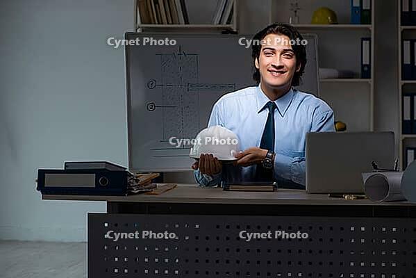 Young male architect working night at office [IBR125118028]
