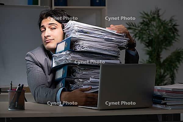 Young male employee working late at office [IBR125118035]