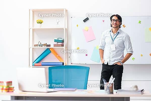 Young handsome male designer working in the office [IBR125118047]