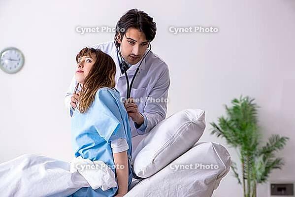 Male doctor visiting female patient in ward [IBR125141677]