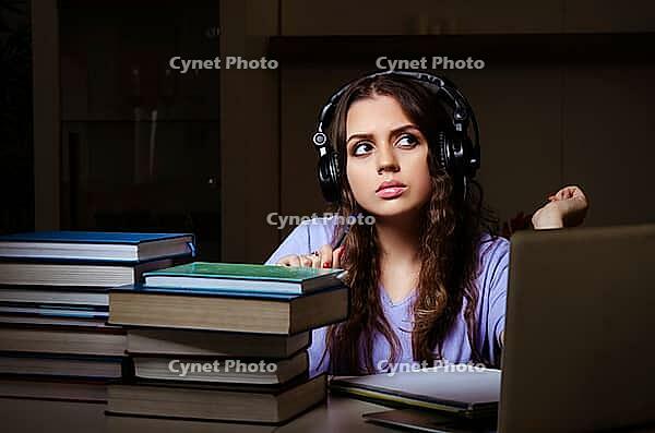Young female student preparing for exams late at home [IBR125141709]