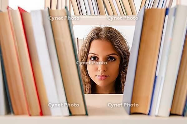 Young female student preparing for exams at library [IBR125141717]