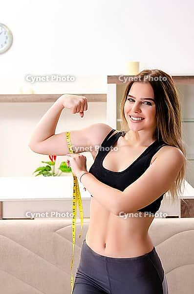 Young beautiful girl with tape meter in dieting concept [IBR125141745]