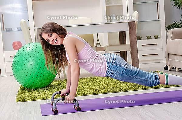 Young beautiful woman doing exercises at home [IBR125141747]