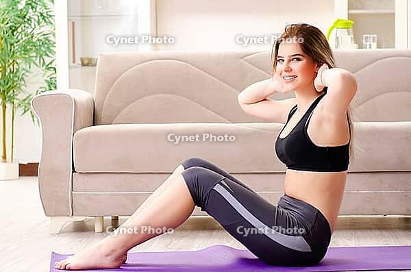 Young beautiful girl doing exercises at home [IBR125141748]