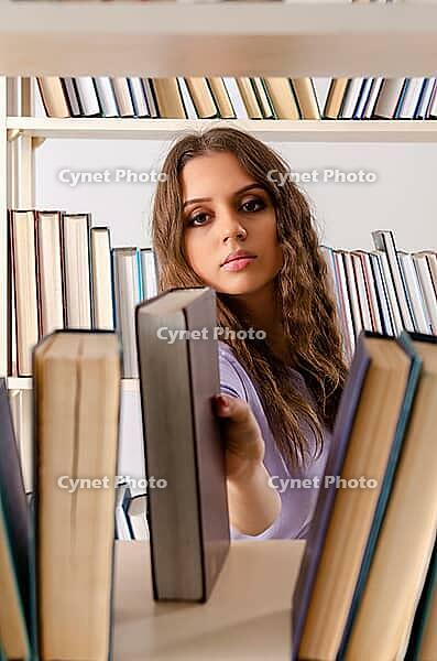 Young female student preparing for exams at library [IBR125141750]