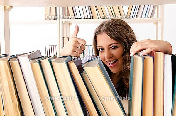 Young female student preparing for exams at library [IBR125141751]