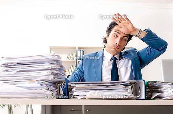 Young handsome busy employee sitting in office [IBR125141756]