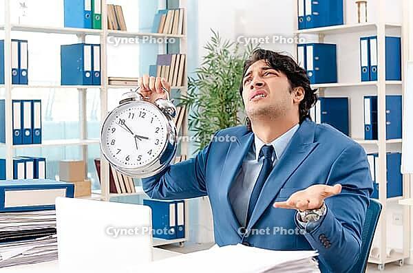 Young handsome male employee with too much work in the office [IBR125141760]