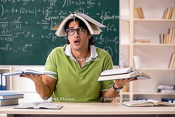 Handsome student in front of chalkboard with formulas [IBR125141769]
