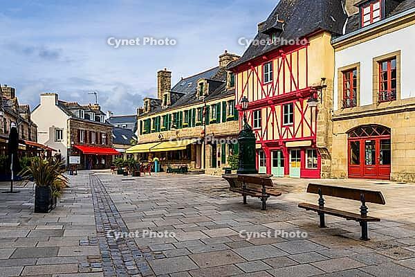 The old town and fortified Ville Close of Concarneau occupy a walled island in the Bay of Concarneau, Finistère, Brittany, France. Stone ramparts, towers, harbour buildings and surrounding water are visible in natural daylight, with the town opening towar [IBR125163361]