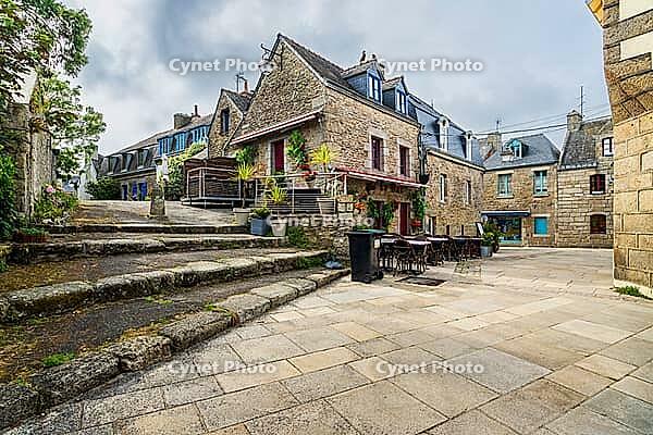 The old town and fortified Ville Close of Concarneau occupy a walled island in the Bay of Concarneau, Finistère, Brittany, France. Stone ramparts, towers, harbour buildings and surrounding water are visible in natural daylight, with the town opening towar [IBR125163363]