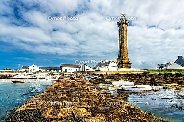 The Phare d'Eckmühl rises above Pointe de Saint-Pierre in Penmarc'h, Finistère, Brittany, France. Its tall stone tower and lantern dominate the low Atlantic coastal landscape, with surrounding lighthouse buildings, rocky ground and open sky visible in cle [IBR125163367]