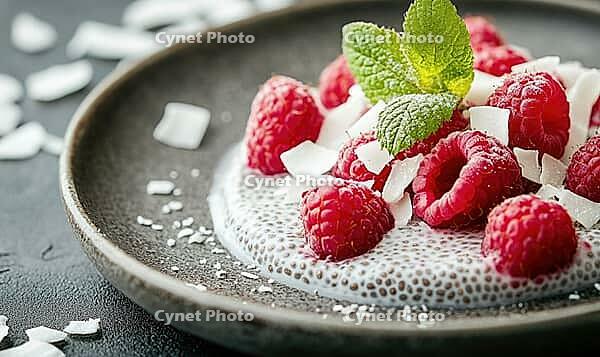 Yogurt and honey-topped chia pudding with raspberries and coconut on a rustic dark plate. AI generated [IBR125167405]