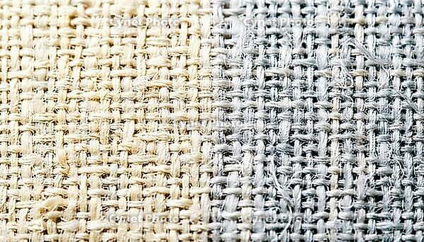 Cotton plain-weave fabric macro texture, left two-thirds in visible light warm ivory tones transitioning to right third in simulated near-infrared spectral response, cool silver-white, NIR spectroscopy textile fiber identification concept, studio shot, AI [IBR125167441]