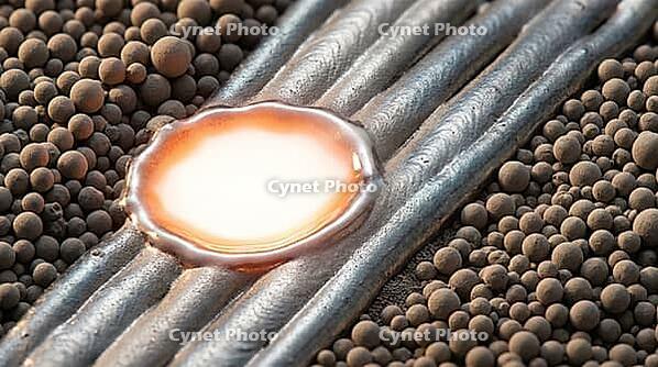 Titanium alloy laser powder bed fusion melt pool at extreme macro scale, showing powder particles, incandescent liquid melt zone and solidified metal tracks simultaneously, additive manufacturing process concept, studio shot, AI generated [IBR125167445]