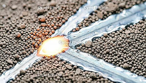 Titanium alloy laser powder bed fusion melt pool at extreme macro scale, showing powder particles, incandescent liquid melt zone and solidified metal tracks simultaneously, additive manufacturing process concept, studio shot, AI generated [IBR125167449]