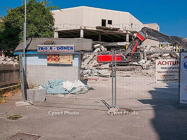 Demolition excavator next to a abandoned doner kebab snack [IBR125180343]
