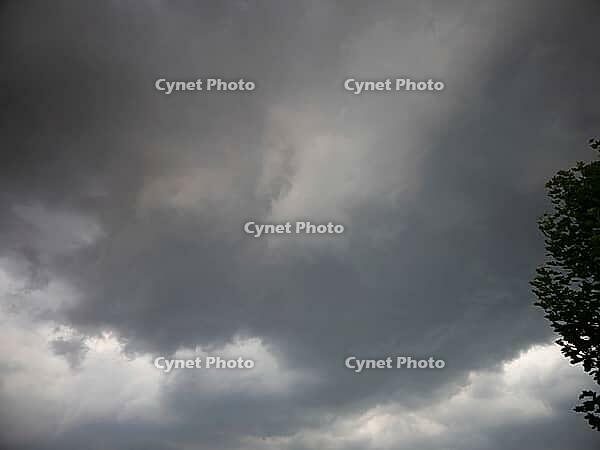 Dark clouds in the sky that create an ominous atmosphere with a tree on the edge, heavy cloudiness in the sky in 27798 Hude, Germany [IBR125185856]