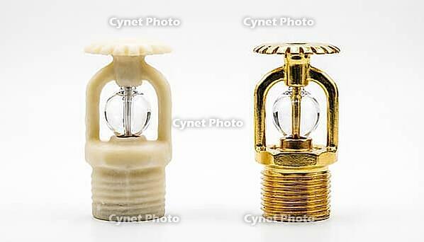 Two new fire sprinkler heads side by side, left with cream-white wax corrosion-resistant coating, right with standard bright brass finish, fire protection maintenance decision and chemical facility safety concept, white background, studio shot, AI generat [IBR125200731]