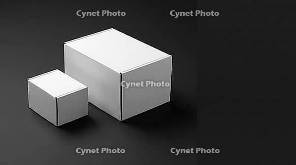 Two plain white matte cardboard boxes side by side, right box 2.26 times larger than left, representing declared versus actual chemical storage quantity discrepancy, industrial compliance and warehouse safety gap concept, dark charcoal background, studio  [IBR125200739]