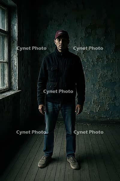 A man stands solemnly in a dimly lit, peeling walled room, creating a mysterious and moody atmosphere, AI generated [IBR125203205]