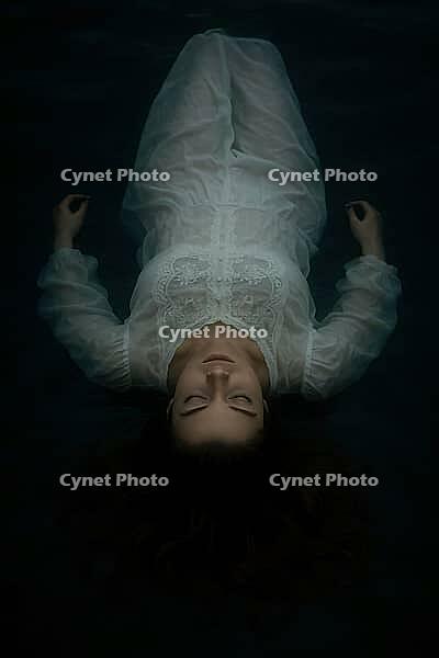 Woman in a white dress floats peacefully on water at night, creating a mystical, calm scene, AI generated [IBR125203224]