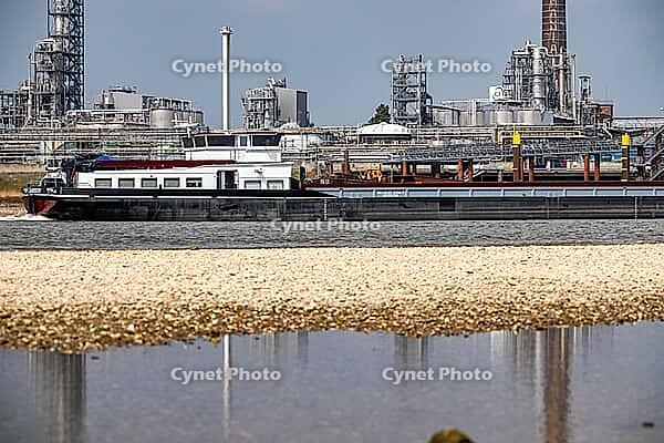 Rhine near Emmerich, extreme low water, Rhine level at 5 cm, downward trend, cargo ships sometimes have to travel with only 30 percent of the usual load, backdrop of the KLK Emmerich chemical plant, for oleochemical products, North Rhine-Westphalia, Germa [IBR113322387]