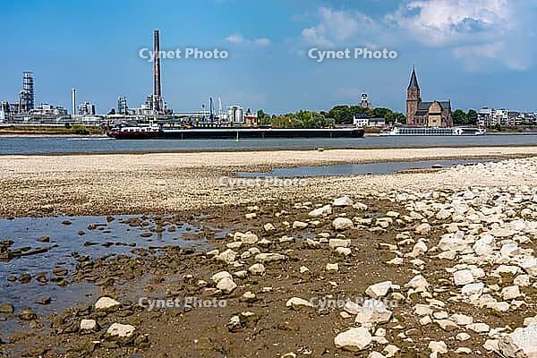 Rhine near Emmerich, extreme low water, Rhine level at 5 cm, downward trend, cargo ships sometimes have to travel with only 30 percent of the usual load, backdrop of the KLK Emmerich chemical plant, for oleochemical products, North Rhine-Westphalia, Germa [IBR113322435]