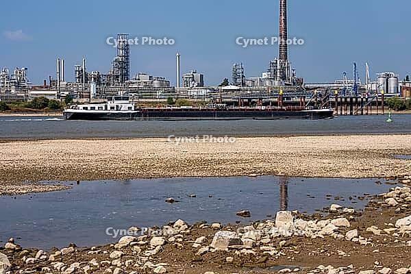 Rhine near Emmerich, extreme low water, Rhine level at 5 cm, downward trend, cargo ships sometimes have to travel with only 30 percent of the usual load, backdrop of the KLK Emmerich chemical plant, for oleochemical products, North Rhine-Westphalia, Germa [IBR113322465]