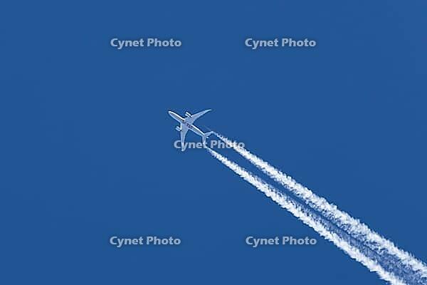 Jet passenger aircraft of TUI airlines flying in a blue sky with contrails or vapour trails behind in the atmosphere, England, United Kingdom [IBR125204134]