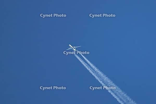 Jet passenger aircraft of TUI airlines flying in a blue sky with contrails or vapour trails behind in the atmosphere, England, United Kingdom [IBR125204147]