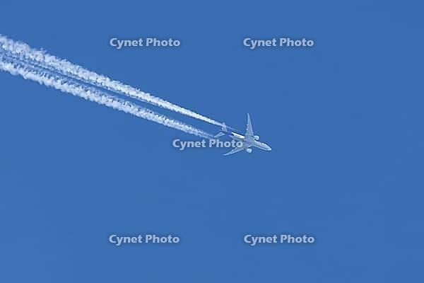 Jet commercial cargo aircraft of Fedex express airlines flying in a blue sky with contrails or vapour trails behind in the atmosphere, England, United Kingdom [IBR125204178]
