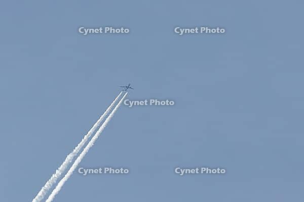 Jet passenger aircraft flying in a blue sky with contrails or vapour trails behind in the atmosphere, England, United Kingdom [IBR125204182]