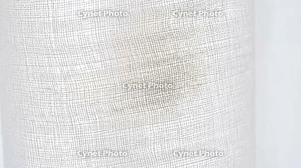 Sheer curtain fabric weave with a barely perceptible residue tint in one section, indoor smoke contamination concept, studio shot, AI generated [IBR125211468]