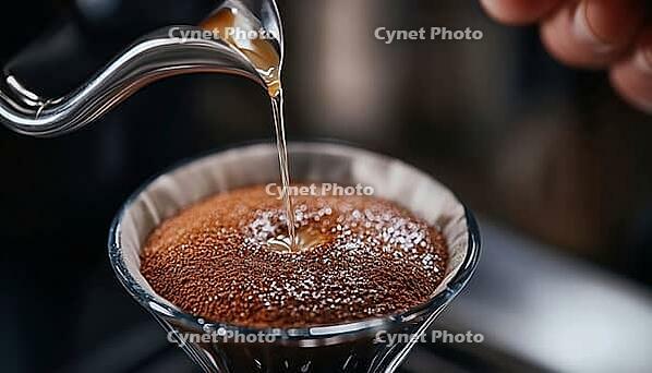 Close-Up Shot Of A Hand Demonstrating The Drip Coffee Or V60 Method, Pouring Hot Water From A Kettle Onto Ground Coffee In A Funnel For Homemade Coffee, AI generated [IBR125229907]
