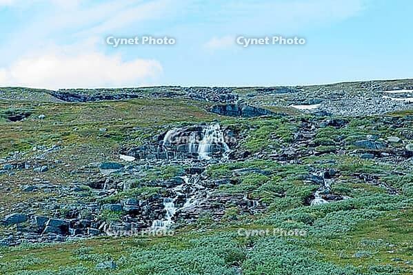 Small mountain stream waterfall cascading over rock formations in summer, Storfjord, Norway [IBR125242438]