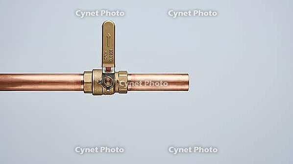 Ordinary copper pipe with a closed shutoff valve, calm exterior hiding the violent pressure transient of water hammer, studio shot, AI generated [IBR125242470]