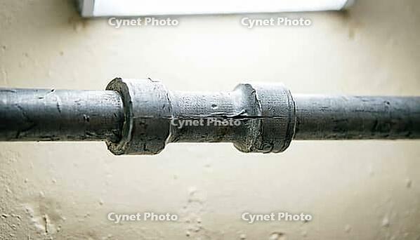 Extreme macro of a pipe support bracket with a barely perceptible gap from its mounting mark, evidence of water hammer vibration damage, studio shot, AI generated [IBR125242471]