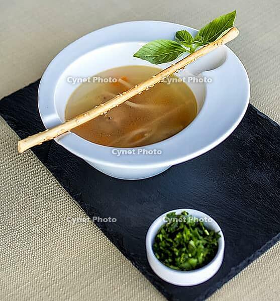 Tasty soup with greens on the black plate [IBR125261548]
