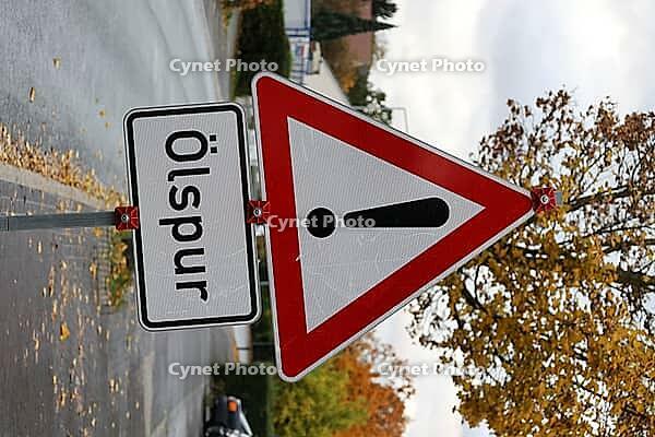 Danger from oil slick: warning sign on the side of the road [IBR125280358]