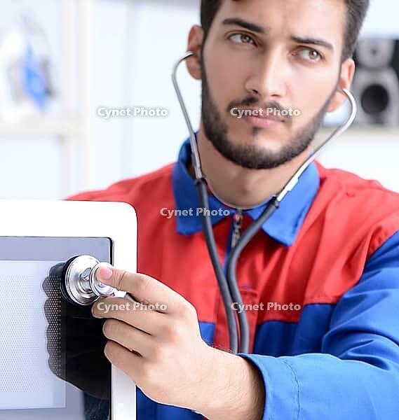 The young mechanic repairs and repairs the microwave oven [IBR125304618]