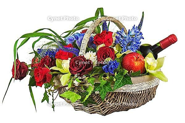 Flower arrangement of roses, orchids, fruits and bottle of wine in basket isolated on white background. Closeup [IBR125304683]