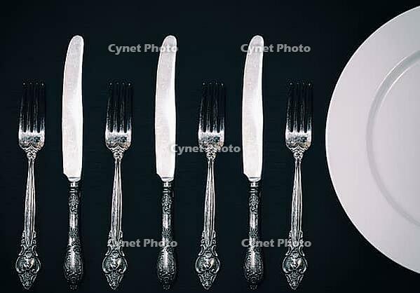 Half empty white plates, vintage knife and fork on black table, view from above [IBR125331115]