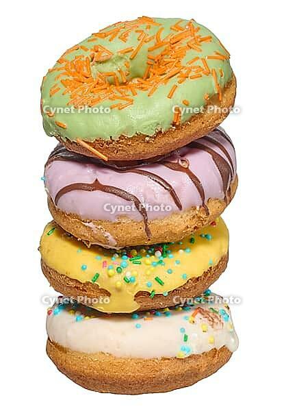 Stack of four colorful glazed donuts with assorted sprinkles and toppings, isolated background [IBR125331120]