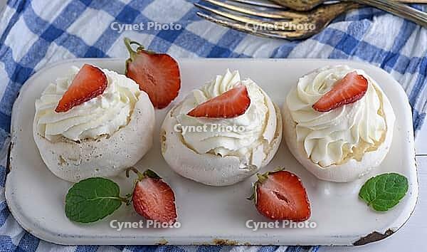 Baked meringue with cream and fresh strawberries, top view [IBR125331154]